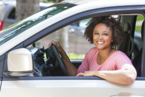 Femme africaine souriante dans sa voiture 